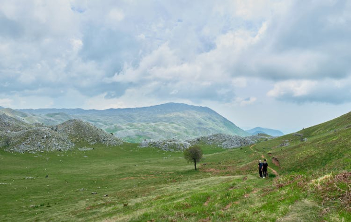 adventure,albania,countryside,grass field,green,hikers,hiking,hill,landscape,mountain,nature,people,rural,valley,white clouds