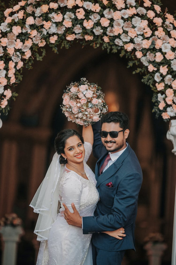 affectionate,arch,arches,beard,black hair,bouquet,bride,bridegroom,bunch of flowers,cheerful,couple,embracing,entrance,entrances,excitement,garland,hair back,happiness,holding,joy,long hair,loving,marriage,mustache,romance,short hair,sunglasses,together,tuxedo,veil,vertical shot,wedding,wedding dress,wedding photography