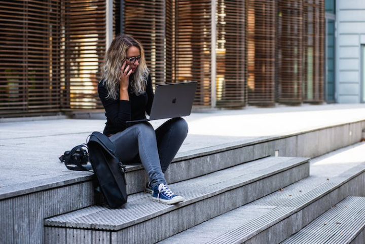 adult,architecture,backpack,building,business,businesswoman,cellphone,city,girl,laptop,macbook,macbook pro,millennial,outdoors,person,remote work,sit,stairs,step,street,technology,woman,working