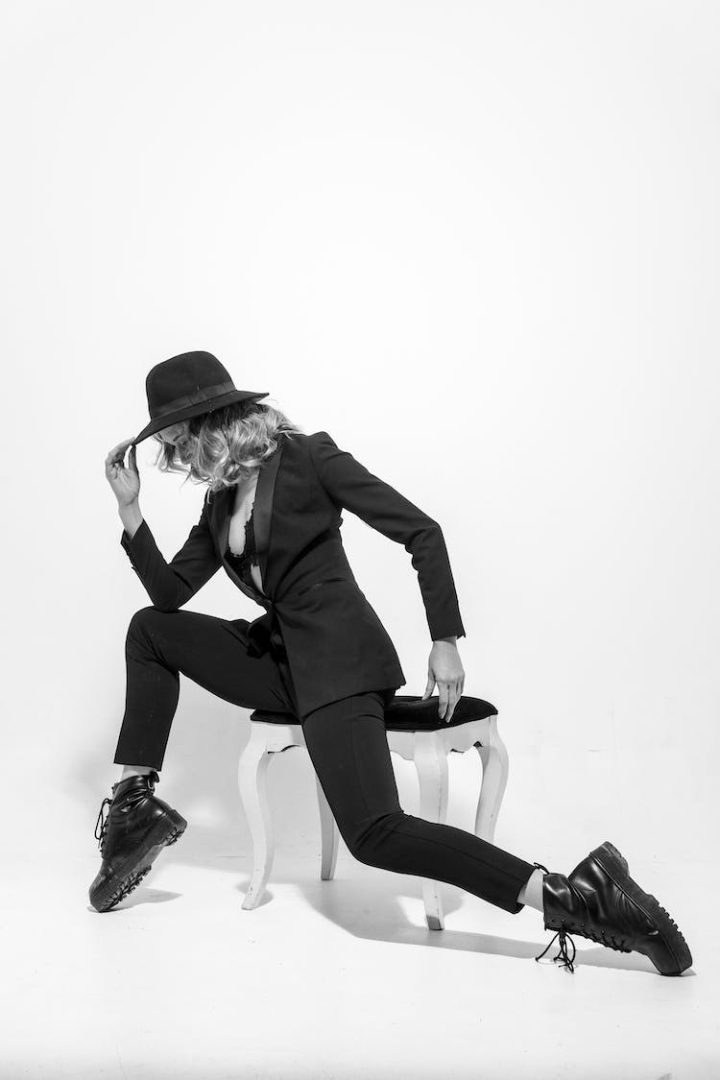 black and white,dynamic pose,elegant,fashion,hat,model,posing,studio shoot,style,suit,vertical shot,woman