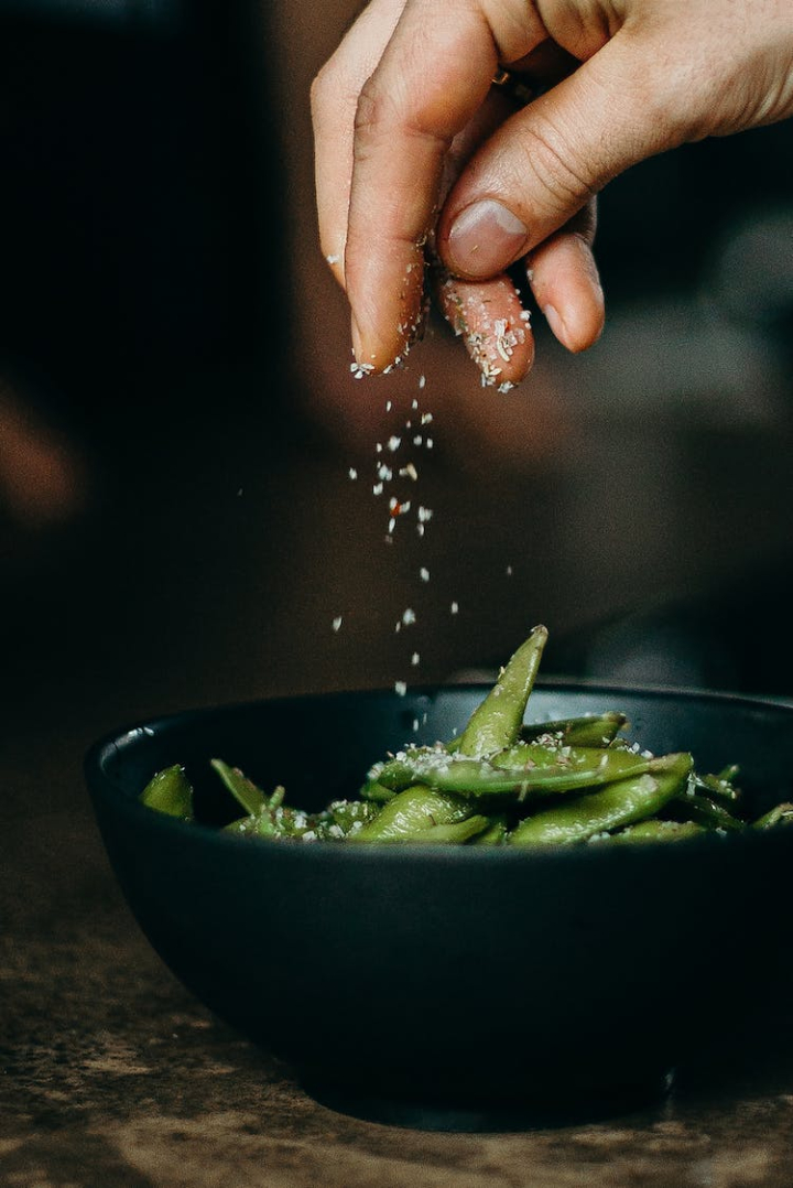 adult,beans,bowl,chef,close-up,cooking,cookware,delicious,edamame,food,food photography,food preparation,fresh,green,hand,healthy,indoors,meal,person,preparation,salt,seasoning,tasty,vegetable,woman