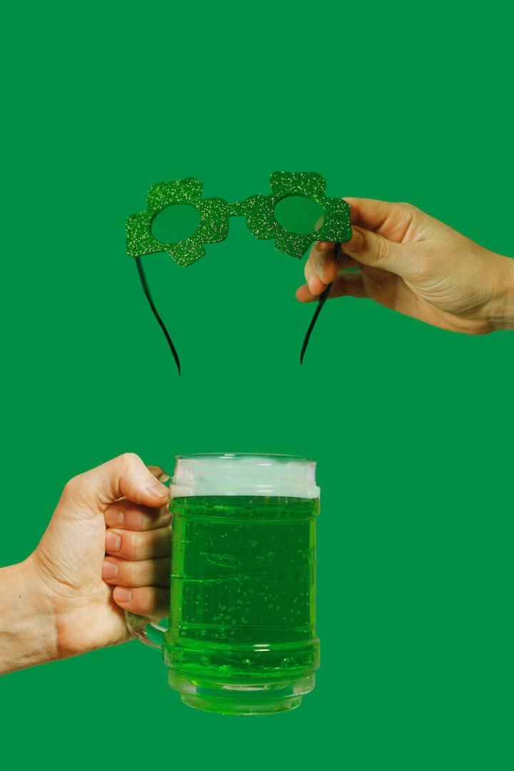 alcohol,alcoholic beverage,beer,clover,drink,foam,glass,glasses,green,hand,holding,luck,saint patrick s day,st patrick s day