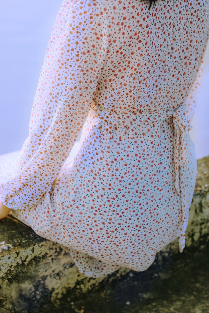 35mm film,analog photography,back,color,dreamy,dress,film photo,film photography,outdoors,pattern,person,sit,sitting,woman