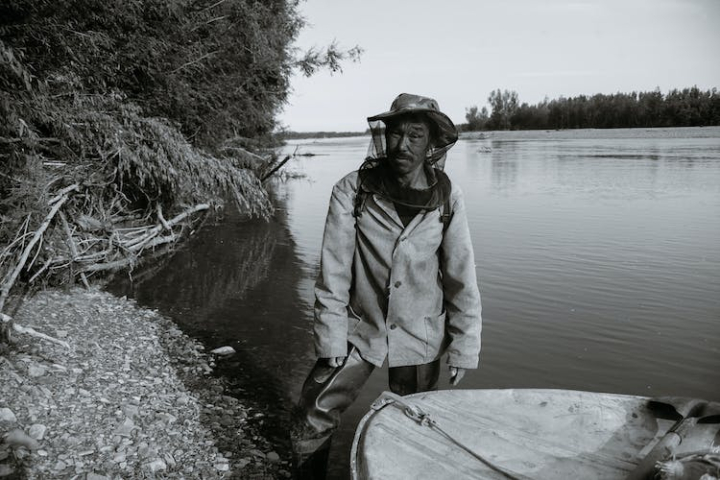 alone,blurred background,boat,bw,calm,coast,concentrate,contemplate,daytime,environment,ethnic,fisherman,fishing,forest,hat,hobby,horizontal,idyllic,indigenous,lake,lakeside,lifestyle,looking at camera,male,man,mature,nature,net,outdoors,peaceful,pensive,pond,poor,poverty,quiet,rural,serious,shallow,shore,silent,sunlight,tradition,tranquil,tree,water,wistful