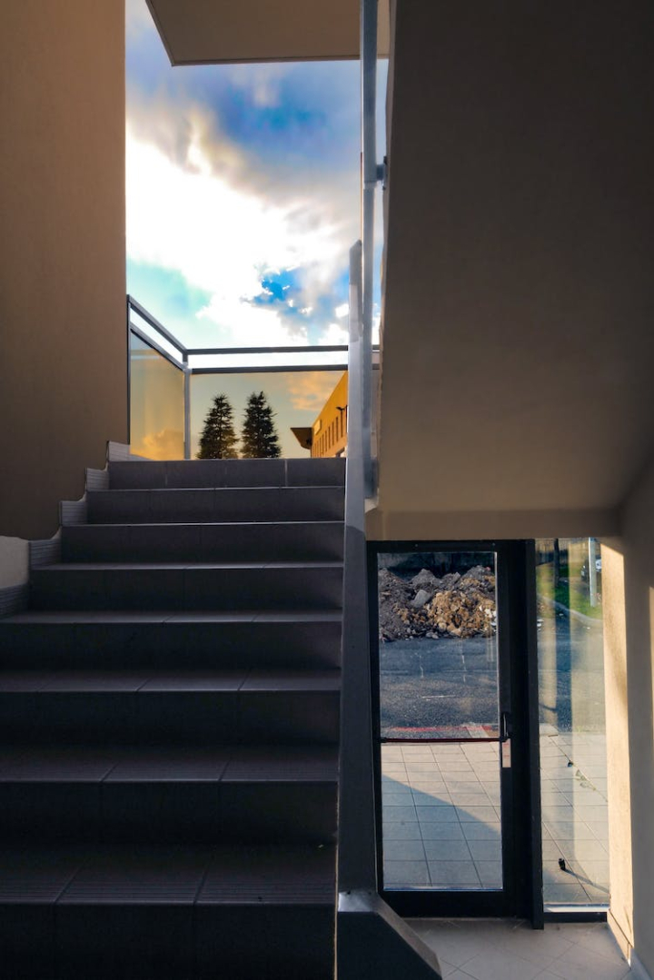 architecture,building,clouds,concrete,design,glass door,glass items,railing,sky,stairs,steps,vertical shot