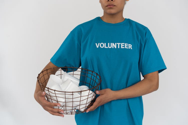 blue shirt,disposable cups,environmental conservation,environmentalist,holding,metal basket,person,plastic,volunteer,white background