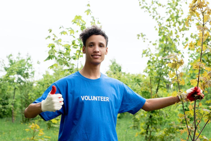 active,blue shirt,boy,community,concept,earth,ecology,enjoyment,environment,fun,glove,green,hands,holding,leisure,man,nature,outdoors,park,person,plant,smiling,summer,thumbs up,volunteer,young