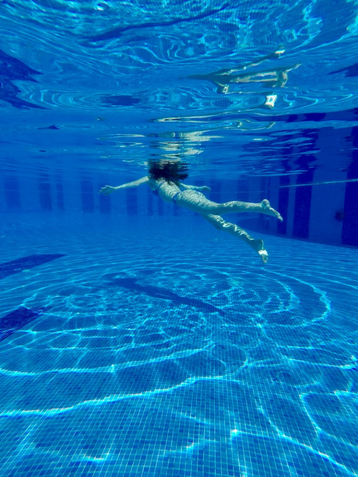 back view,dug out pool,person,reflection,swimming,swimming pool,turquoise,underwater,vertical shot,water,wet,woman