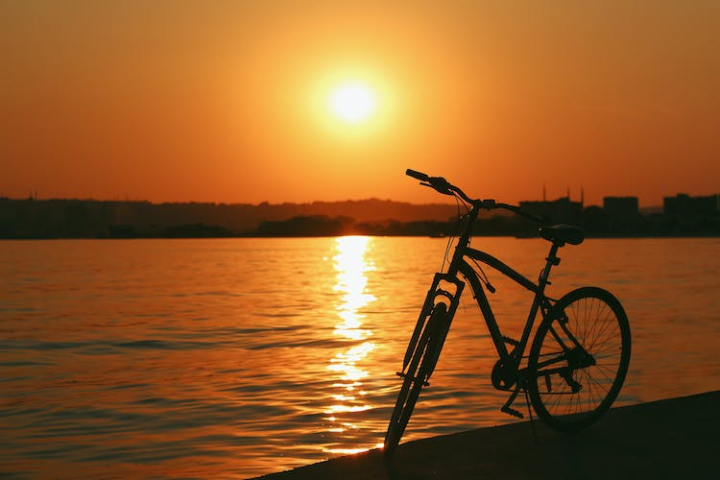 back lit,bicycle,dramatic sky,golden hour,reflection,river,silhouette,sunset