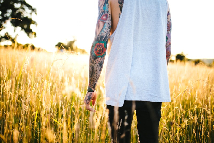 tattoo,tattoo man,grass,tattooed man,skin clothing,grass backgrounds,wheat field,man,man nature,person photo,nature,tattoo sleeve,rawpixel