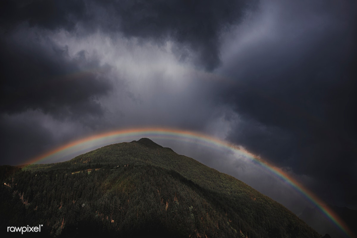 Free: Rainbow over a mountain on a cloudy day