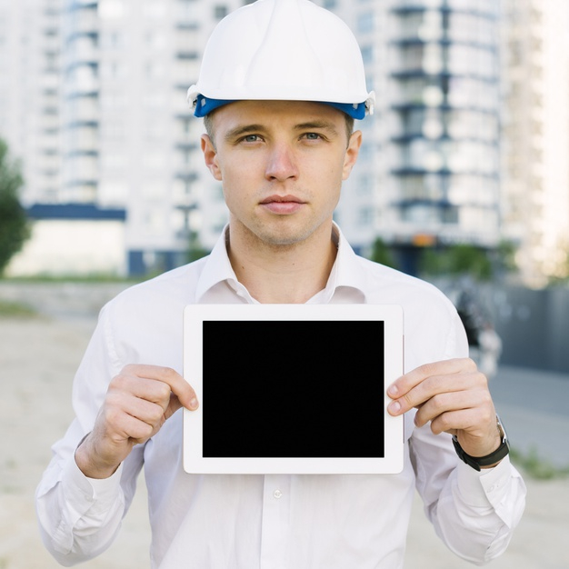 medium shot,medium,front,outdoors,shot,holding,up,device,view,architect,professional,outdoor,project,helmet,safety,tablet,job,architecture,person,work,construction,man,building,technology,design,mockup