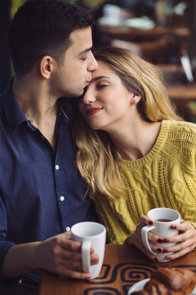 indoors,flirting,cheerful,boyfriend,casual,girlfriend,laughing,adult,holding,drinking,relationship,male,hug,sitting,young,together,talking,female,kiss,fun,cup,drink,couple,cafe,shop,happy,tea,valentine,girl,man,woman,love,coffee