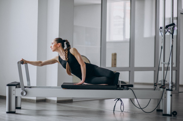 A Woman in Activewear Doing Pilates Reformer Exercise · Free Stock Photo