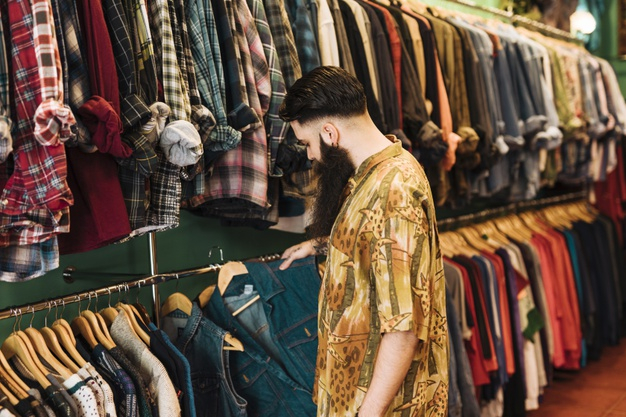 Free Photo, Young handsome man choosing clothes at shop