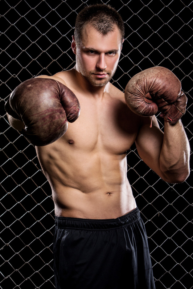 Free: Guy with a boxing gloves showing muscles on fence Free Photo 