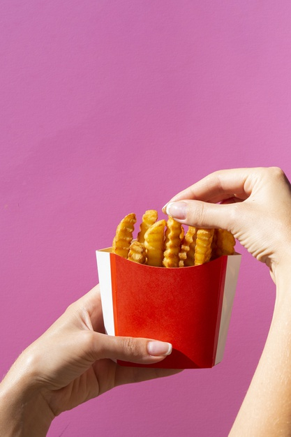 copy space,salty,calories,tasty,potatoes,copy,fries,french,french fries,salt,fast,eating,female,brown,energy,golden,space,red,pink,hands,box,woman,restaurant,food,background