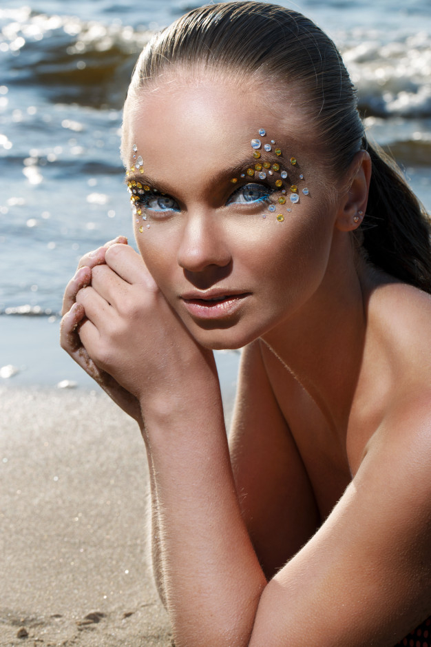 Female young adult in bikini holding seashell - Stock Photo