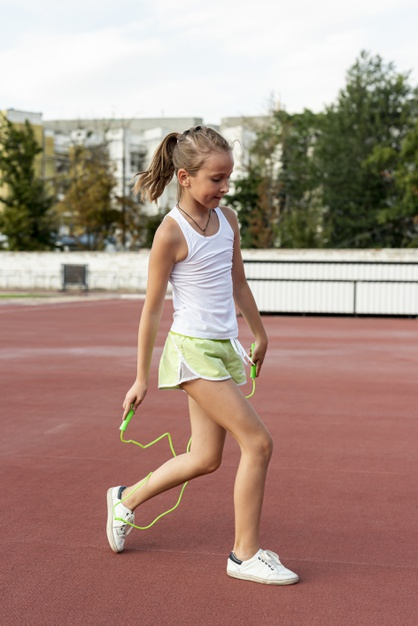 full shot,jumprope,side view,little,outside,sporty,side,full,outdoors,shot,shorts,view,exercise,healthy,child,kid,cute,health,girl,sport,green