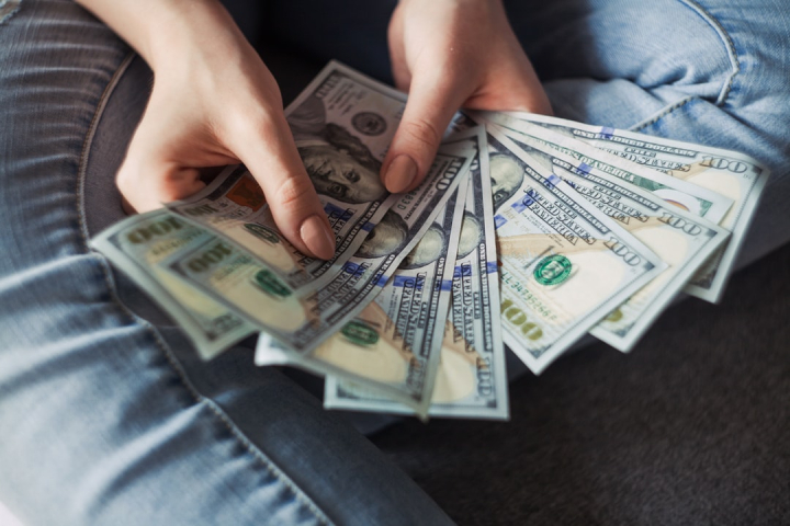Woman holding 100 dollar bills hi-res stock photography and images
