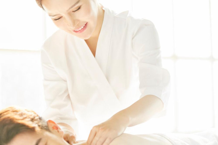 Man giving woman a shoulder massage Stock Photo