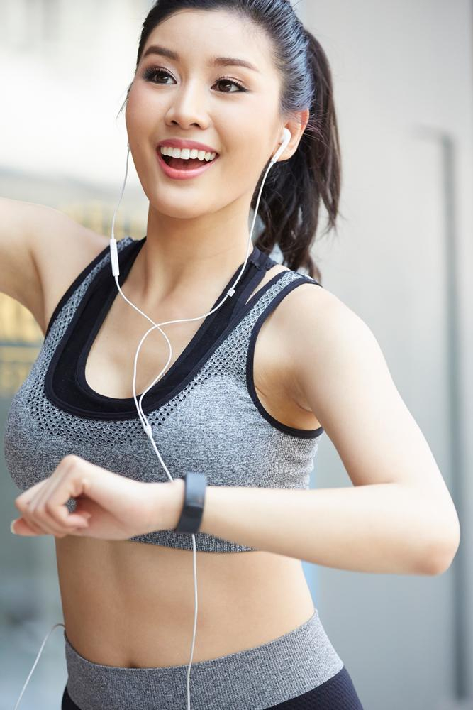 Doing sport. Young active fit woman with long legs listening to music and  doing sport Stock Photo - Alamy