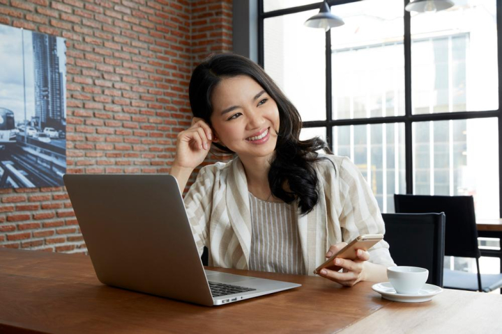 woman,cup,glass,coffee,wall,photograph,female,alone,25-30 years,black,wooden,smiling,asian ethnicity,caucasian ethnicity,happy,beautiful,face,excited,office,holding,smartphone,using,shirt,polite,hairstyle,beauty,white,pretty,table,sitting,long hair,bulb,successful,working,touch,laptop,business,thai,thailand,thai people,asia,asian people,xframe