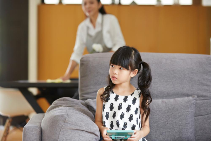 girl,kid,child,children,little girl,sitting,sofa,living room,at home,indoors,asian,asia,thai,sister,portrait,casual clothes,holding,lovely,cute,cheerful,lifestyle,oriental,daughter,looking,handheld game,a photo of,daytime,relaxing,pretty,healthy,rest,long hair,black hair,adorable,mom and kid,housewife,housework,xframe