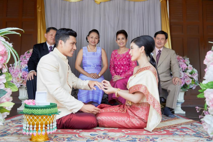 bride,groom,sitting,looking,smiling,together,male,female,man,woman,couple,love,family,relatives,husband,wife,congratulation,thailand,thai style,traditional,vintage,beautiful,engagement,group,six,people,bridal,asia,asian,thai,religion,religious,jasmine,flower,pot,sacred,happiness,elegant,dress,buddhist,buddhism,wedding,mariage,married,celebration,wearing,ring,finger,front,parents,decoration,hand,khan maak,betel bowl,xframe