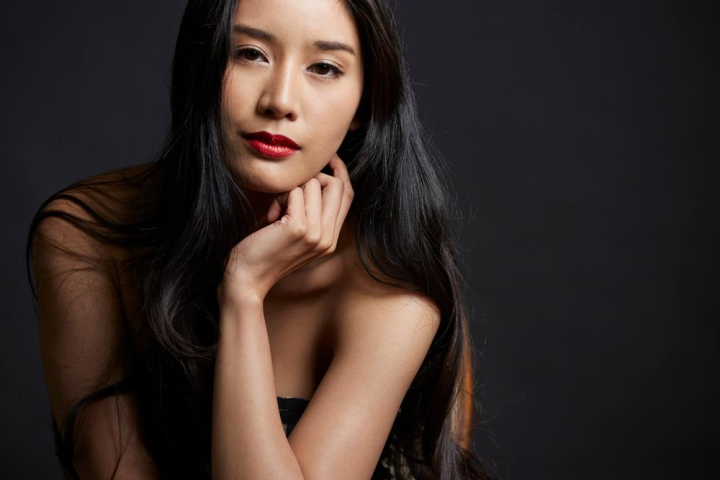 portrait,woman,black dress,sitting,indoors,adult,stylish,asian,studio,attractive,beautiful,shade,beauty,sexy,beauty image,posing,care,person,charming,one,cute,inside,mysterious,east asia,look at camera,female,look,lip,lady,lase,model,oriental,oriental people,fashion,elegant,pretty,elegance,skin,dress,thai,dark,wellness,curly hair,black hair,young,black background,youth,alone,tanned,smooth skin,chair,twenties,girl,clothing,smile,asia,thailand,xframe